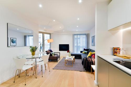 a kitchen and living room with a table and chairs at Madison Hill - Clapham South 1 - Two bedroom flat in London