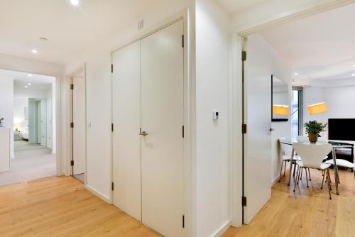 a hallway with white closet doors and a dining room at Madison Hill - Clapham South 1 - Two bedroom flat in London