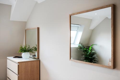 a mirror on a wall next to a dresser at Madison Hill - White Hill House 5 - 3 bedroom flat in London