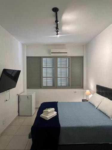 a bedroom with a blue bed and two windows at CoVivere - RJ in Rio de Janeiro