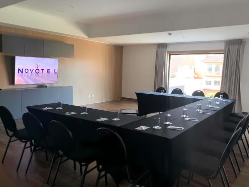 a conference room with a large black table and chairs at Novotel Santa Cruz De La Sierra in Santa Cruz de la Sierra