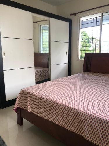 a bedroom with a bed and a chair and windows at 2BHK Fully Furnished at Pukkattupady Cochin in Kakkanad