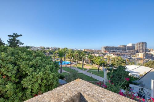 a view of a park with palm trees and buildings at Luxury Villa Sea Views Heart of St Julians in St. Julianʼs