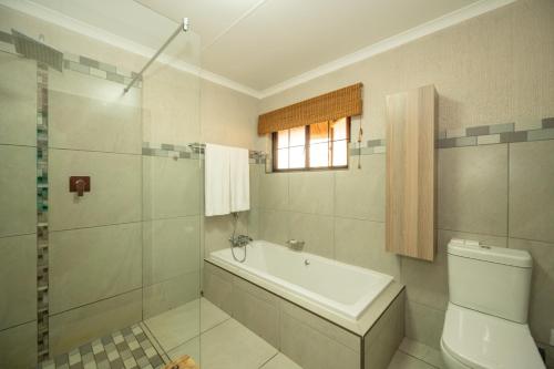 Kruger Park Lodge Unit No 304 في هازيفيو: حمام مع حوض ومرحاض ونافذة