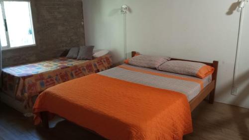 een slaapkamer met twee bedden en een raam bij Posada El Duende in La Pedrera