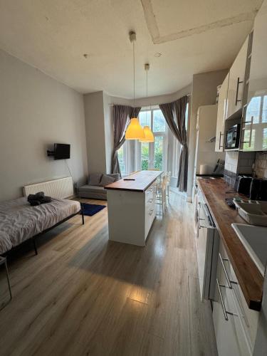 a large kitchen and living room with a table and a couch at Apartment close to City Centre in Winchester