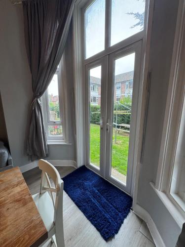 a room with a door with a blue rug and a table at Apartment close to City Centre in Winchester