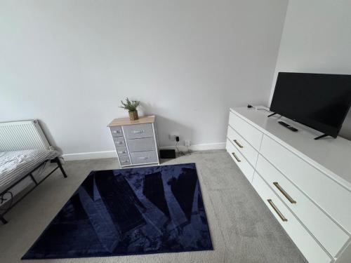 a room with a dresser and a tv and a rug at Apartment close to City Centre in Winchester