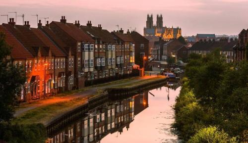 a city with buildings and a river with a city at The Lairgate in Beverley