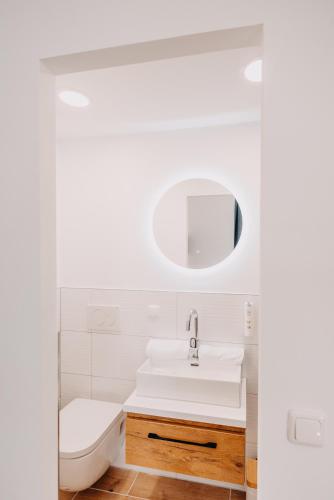 a white bathroom with a sink and a mirror at Aparthotel Arabella Bad Nauheim in Bad Nauheim