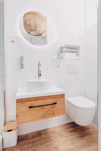 a white bathroom with a sink and a toilet at Aparthotel Arabella Bad Nauheim in Bad Nauheim