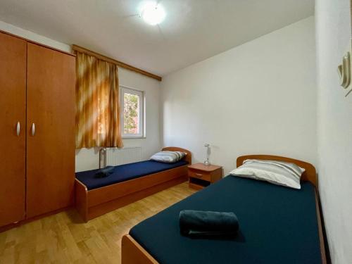 Un dormitorio con dos camas y una ventana en House with outdoor pool in Tisno, en Tisno