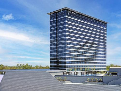 a tall building with a sign on top of it at Swissôtel Clark Philippines in Clark