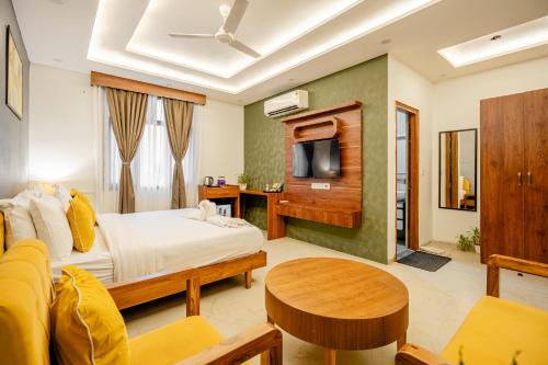 a hotel room with a bed and a table at Lime Tree 3BHK Service Apartment Near India Expo Mart Greater Noida in Greater Noida