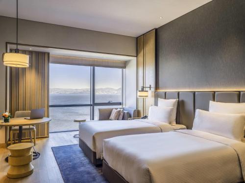 two beds in a hotel room with a view at Pullman Dali in Dali