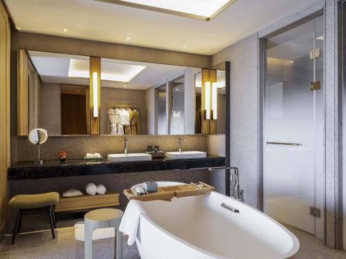a bathroom with a tub and two sinks at Pullman Dali in Dali