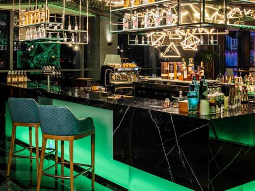 a bar with two chairs and a counter with drinks at Pullman Dali in Dali