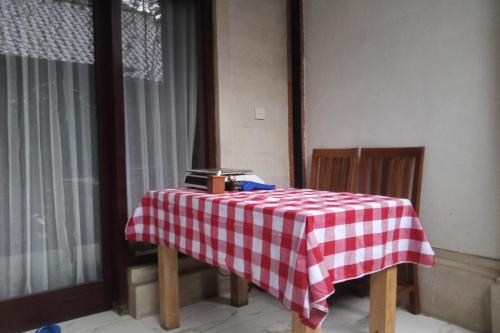 un tavolo con una tovaglia a scacchi rossa e bianca di Bhuana Shanti Homestay Ubud ad Ubud