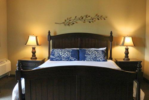 a bedroom with a large bed with two lamps at The Lodge at Woodstone Country Club in Danielsville