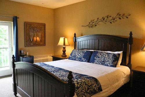 a bedroom with a large bed with blue pillows at The Lodge at Woodstone Country Club in Danielsville