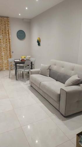 a white living room with a couch and a table at C&C Apartment in Pontecagnano