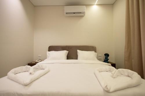 a bed with two heart shaped towels on it at Imperial Luxury Hotel in Cairo