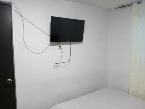 a flat screen tv hanging on a white wall at Hotel Balcon de los Reyes in Tunja