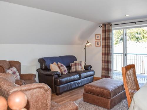 una sala de estar con un sofá y una silla en Ysgubor Blaenparc Barn - Uk41030, en Mydroilin