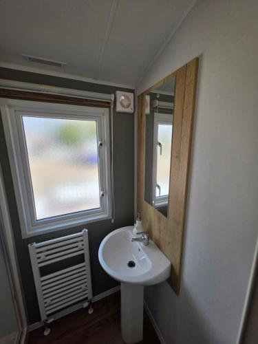 Great ClactonにあるNew - 3 bedroom Caravan, 140 Pasture Laneの洗面台と鏡のあるバスルーム
