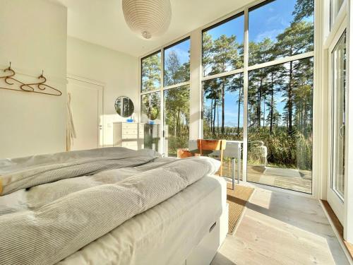 PiggabodaにあるModern Peninsula Cabin With Panoramic Viewの大きなベッドと大きな窓のある寝室