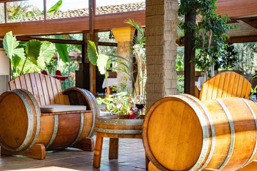a patio with two wooden chairs and two wine barrels at Osman Aga Culture House in Mağusa