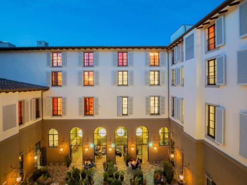 a view of a building with people in the courtyard at 25hours Hotel Florence Piazza San Paolino in Florence