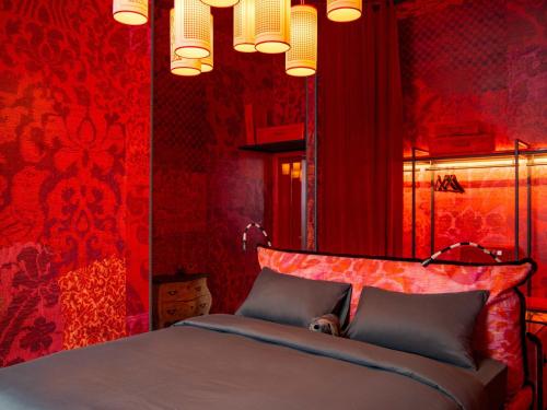 a bedroom with red walls and a bed with two pillows at 25hours Hotel Florence Piazza San Paolino in Florence