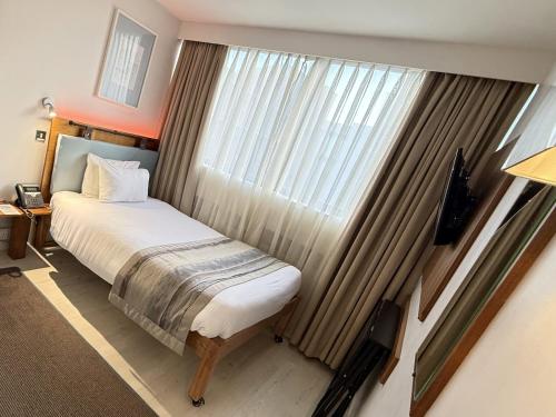 a bedroom with a bed and a large window at Conference Aston Hotel - Birmingham City in Birmingham
