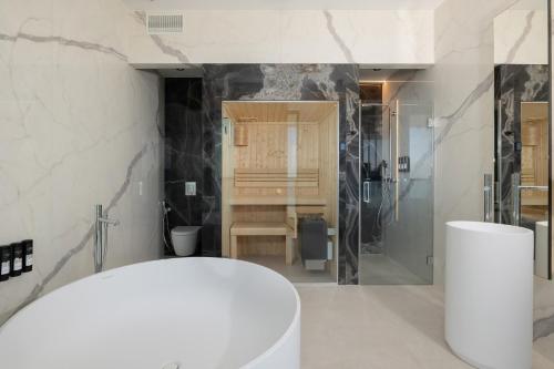 a bathroom with a white tub and a shower at Shellter Hotel Resort & Spa in Rogowo