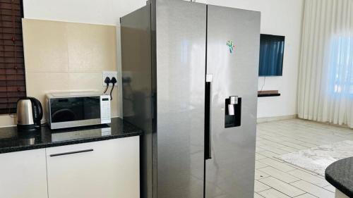 a kitchen with a refrigerator and a microwave at Luxury Two-Story Loft - Beautiful Golf Course Views in Roodepoort