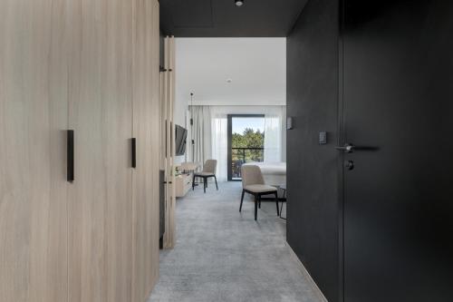 a hallway with a room with a table and chairs at Shellter Hotel Resort & Spa in Rogowo