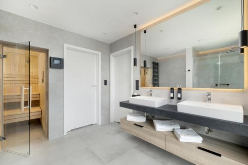 a bathroom with two sinks and a mirror at Shellter Hotel Resort & Spa in Rogowo