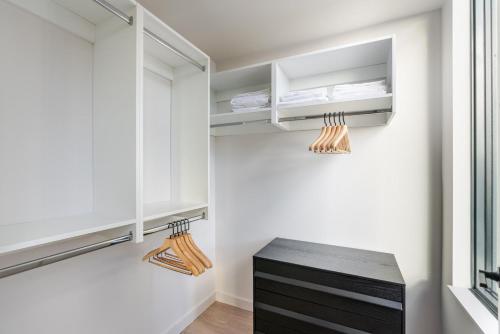 a walk in closet with white cabinets and a black drawer at Blueground Crystal City rooftop pool nr Potomac WDC-1031 in Addison Heights