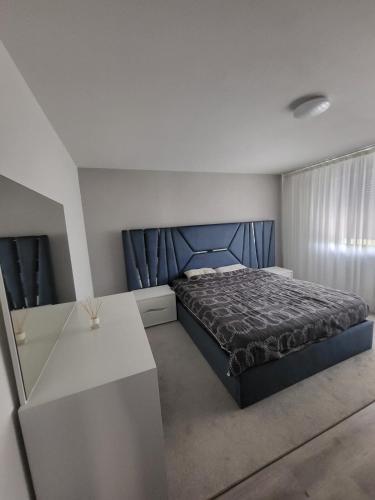 a bedroom with a blue bed and a white table at 5,5 pc apartment, garden but Pool only upon request in Avry