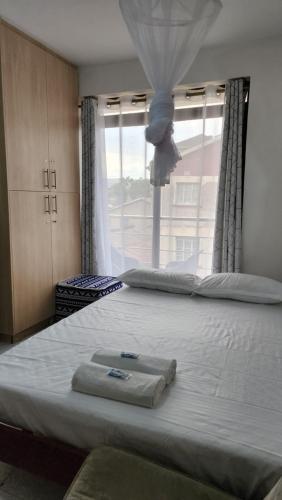 Postel nebo postele na pokoji v ubytování Kisumu Cool Studios