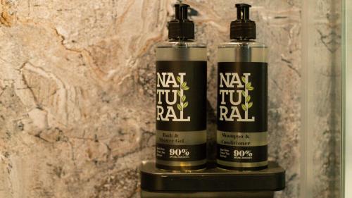 two bottles of nex two rainfall sitting on a shelf at Paradise Penthouse in Downham Market