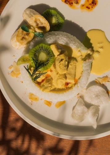 a plate of food with kiwis and fruit on it at Mövenpick Hotel & Apartments Ghala Muscat in Muscat