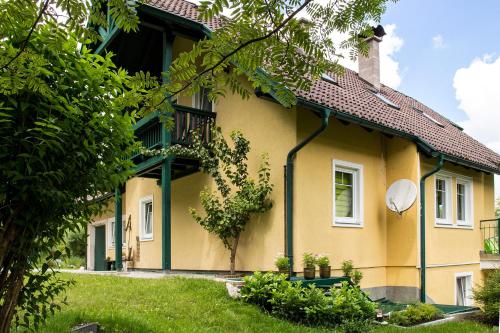 una casa amarilla con un adorno verde en Landhaus HALLSTATT FEELING - Apartment - Self Check-in, en Bad Goisern