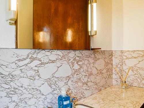 a bathroom with a counter with a sink and a mirror at Woodend Farmhouse Halmyre in Haugh of Urr