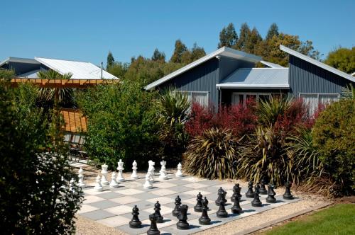 a giant chessboard in a garden in front of a house at The Claremont Motel in Martinborough