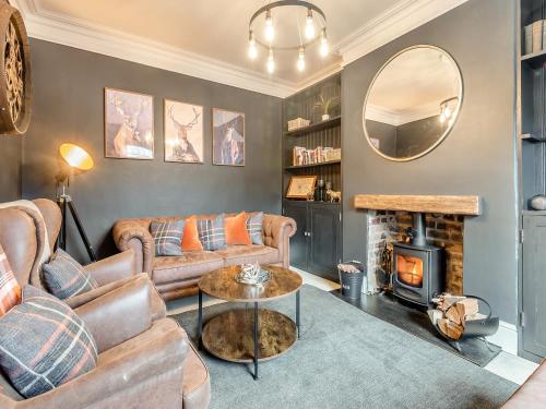 a living room with a couch and a fire place at Skye House in Bakewell