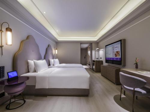 Postel nebo postele na pokoji v ubytování Mercure Dongtai Huanghai Forest