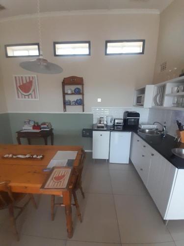 a kitchen with a table and a sink and a table at The Lookout Guest House in Port Alfred