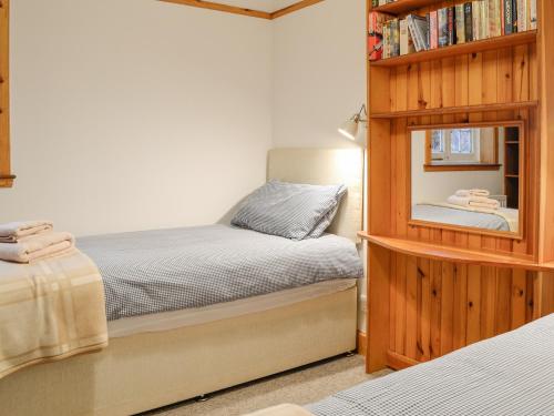 a bedroom with two beds and a book shelf at The Stable-Uk41650 in Blairgowrie